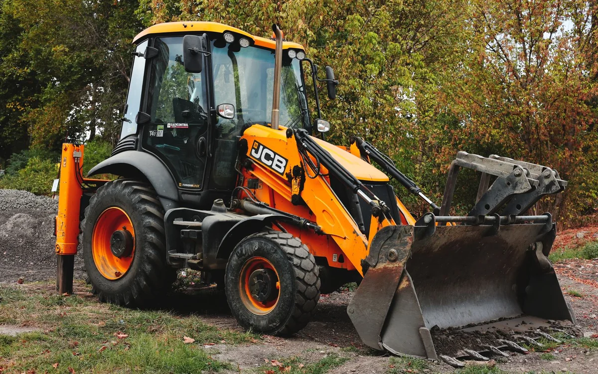 Yellow backhoe loader equipped for digging and loading